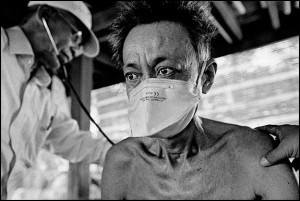 A man with TB is examined during a home visit by a medical worker with the NGO, Cambodian Health Committee, courtesy © James Nachtwey, 2008.