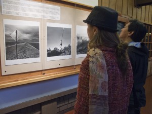 Visitors look at Ken Light's photographs "Sign with Bullets," "Rope Swing," and "Tule Fog" during his opening reception for his book at UC Berkeley. Courtesy, ©Suzie Katz 2012